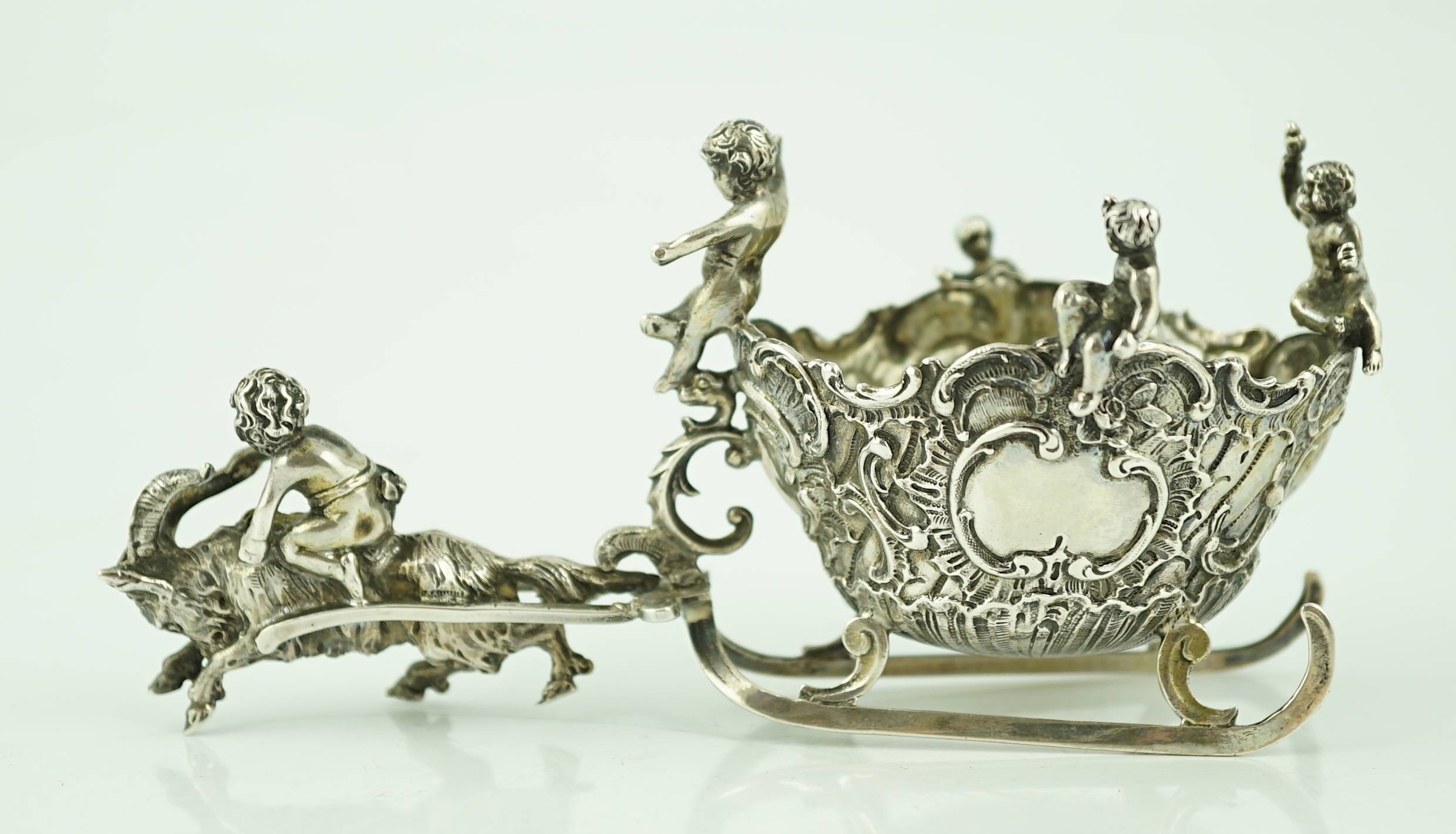 A late 19th century miniature silver model of a sleigh with putti, pulled by a goat, import marks for John George Smith